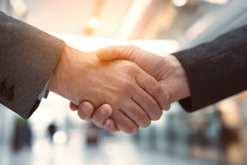 Handshake von erfahrenen IT Business Leuten